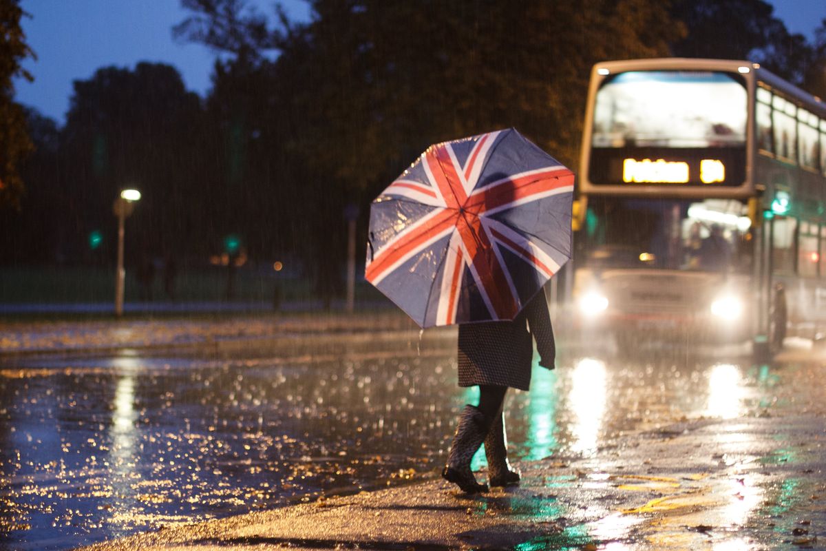 Woman with Union Flag umbrella in heavy rain
