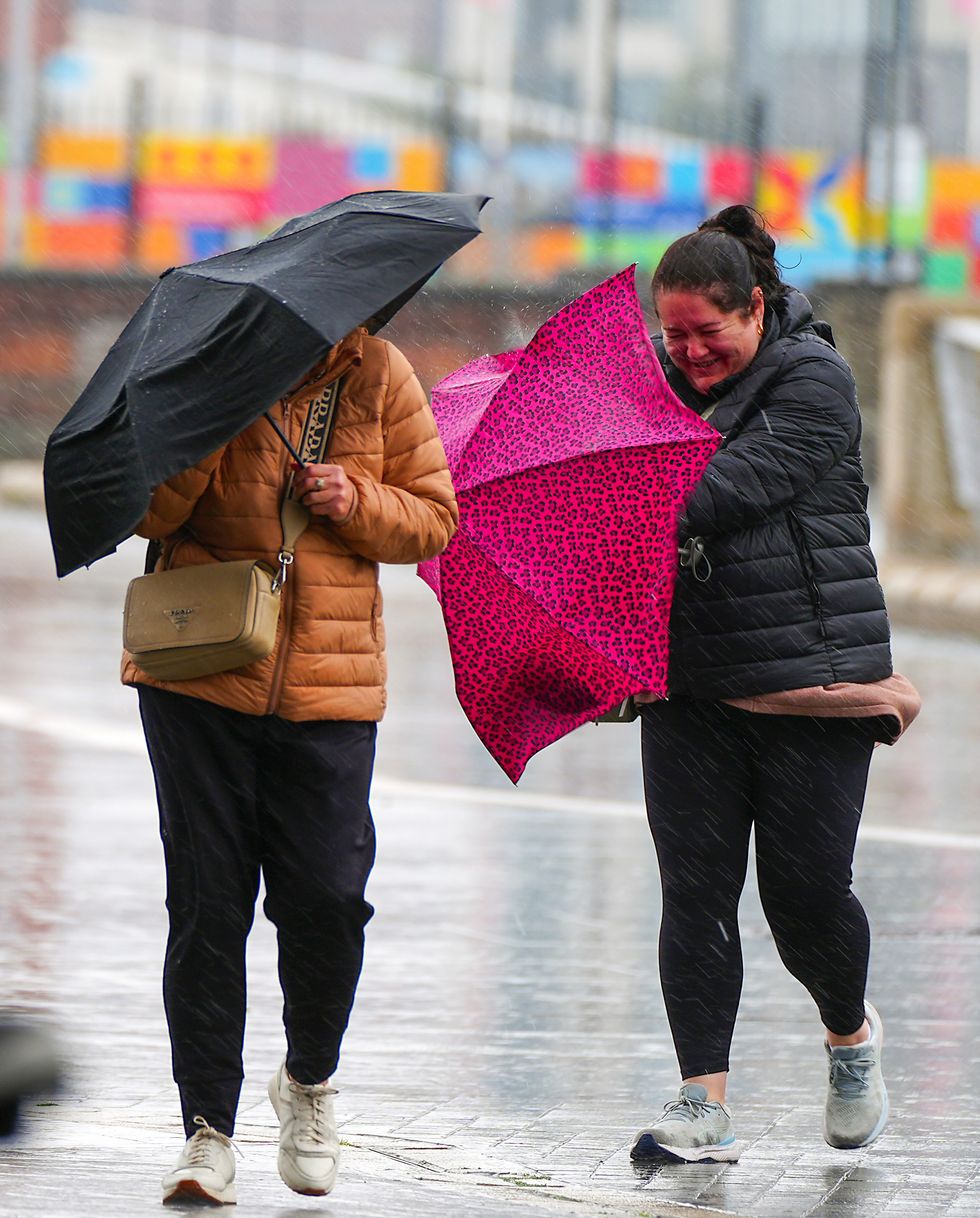 Women in heavy rain with umbrellas