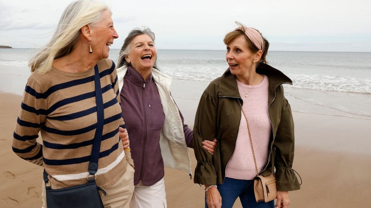 WOMEN WALKING ALONG SHORELINE