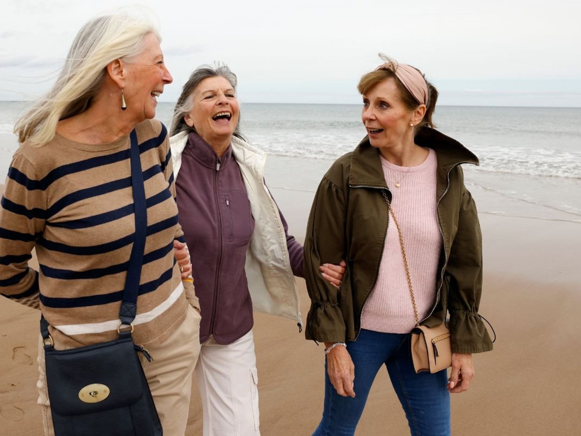 WOMEN WALKING ALONG SHORELINE