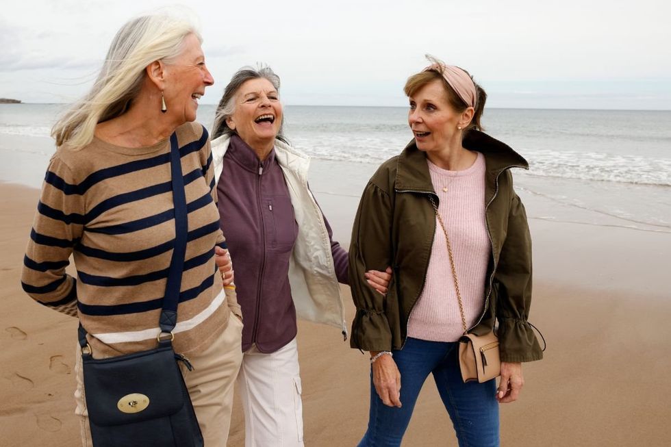 WOMEN WALKING ALONG SHORELINE