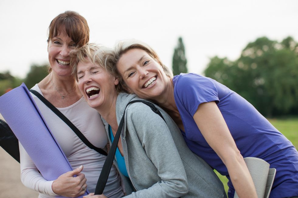 Women with yoga mats, laughing