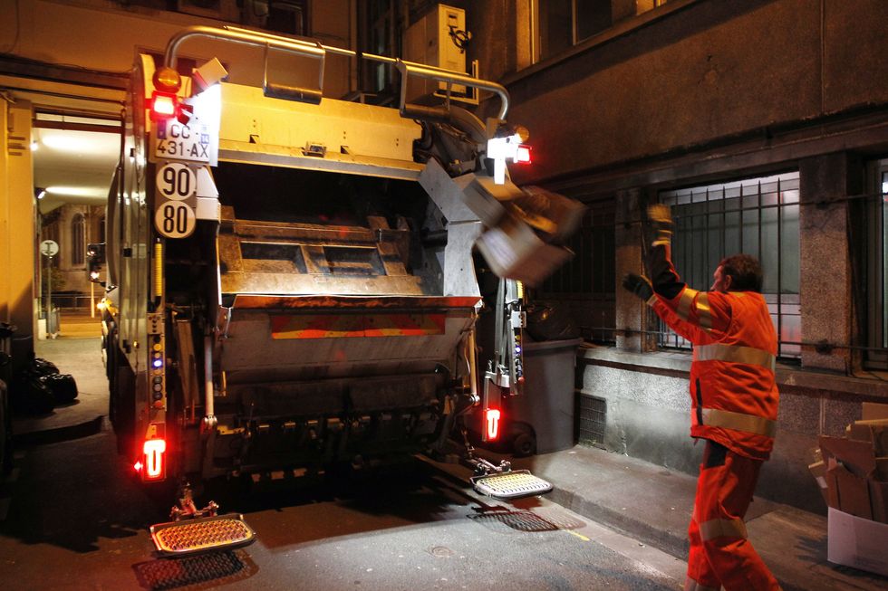 Worker chucking rubbish into a lorry (stock photo)