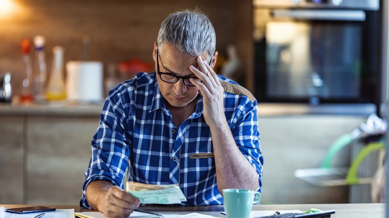 Worker looks worried beside calculator
