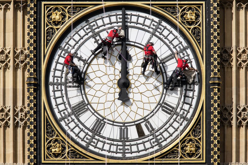 Workers clean the face of Big Ben