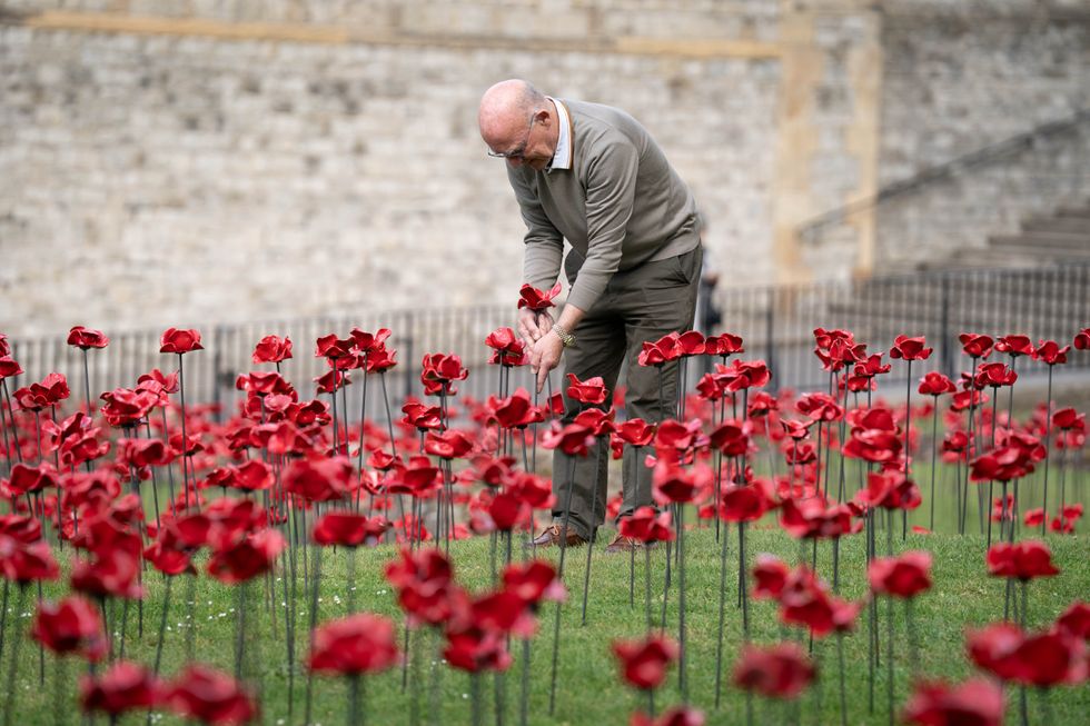 Workers place the first of 30,000 ceramic poppies for the new installation at the Tower of London to mark the 80th anniversary of VE Day