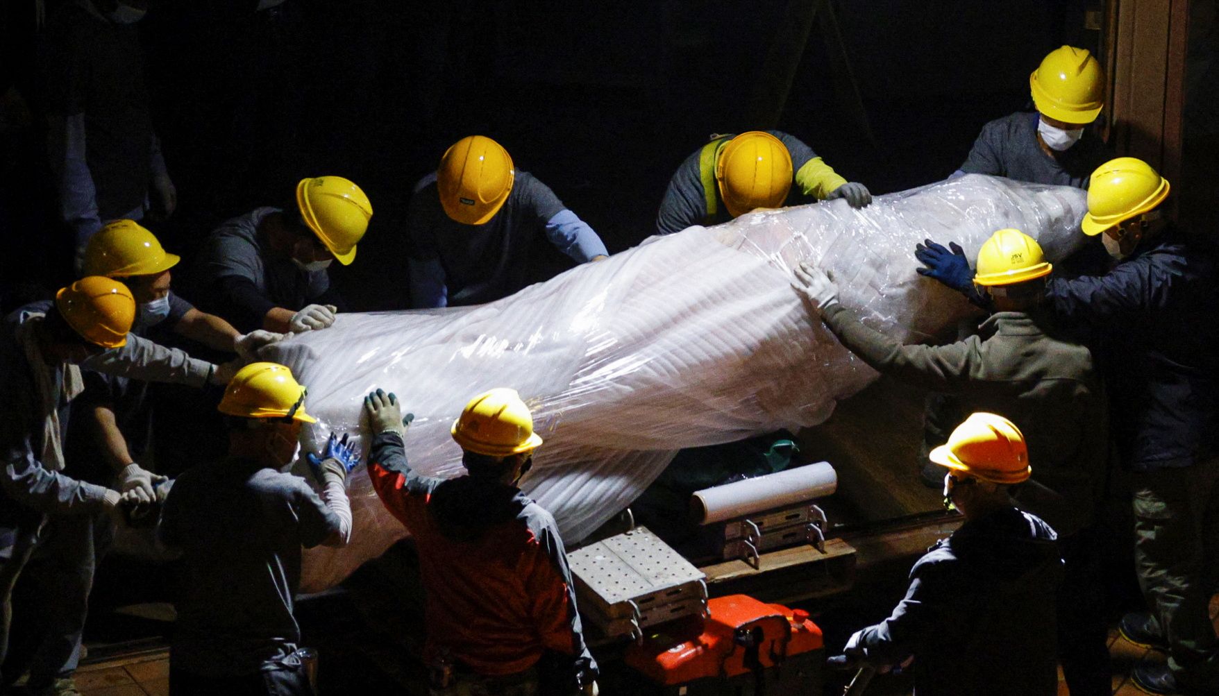 Workers remove a part of %22Pillar of Shame%22 by Danish sculptor Jens Galschiot which to pay tribute to the victims of the Tiananmen Square crackdown in Beijing on June 4, 1989