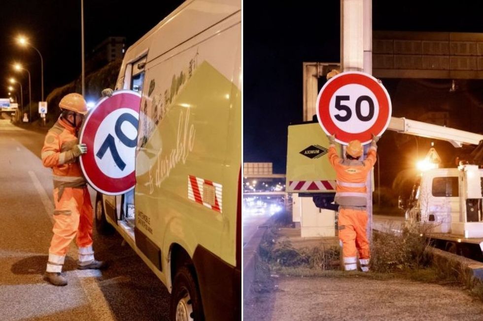 Workers removing a 70km/h sign and installing a 50km/h sign