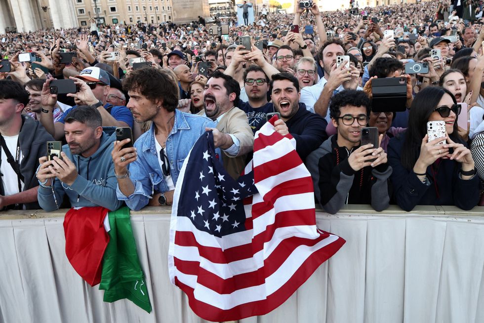 Worshippers hoist the American flag in St Peter's Square as Pope Leo XIV elected