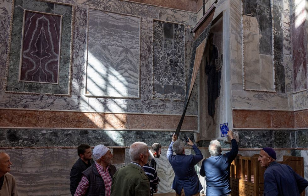 Worshippers look at the covered frescoes before they attend an afternoon prayer at Chora Museum or Kariye Mosque,