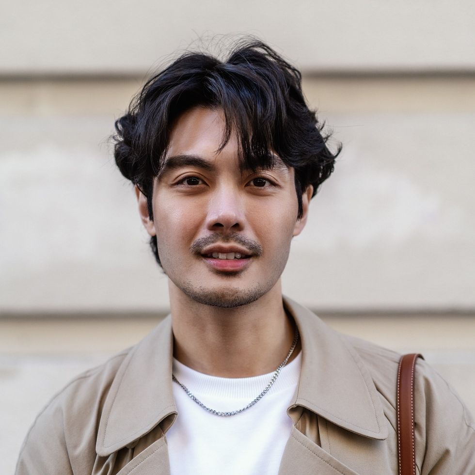 Young man with voluminous dark hair and curtain bangs