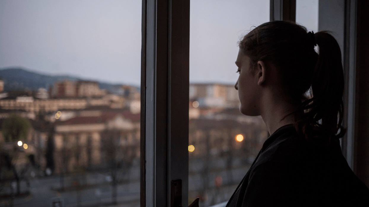 Young woman looking out of window