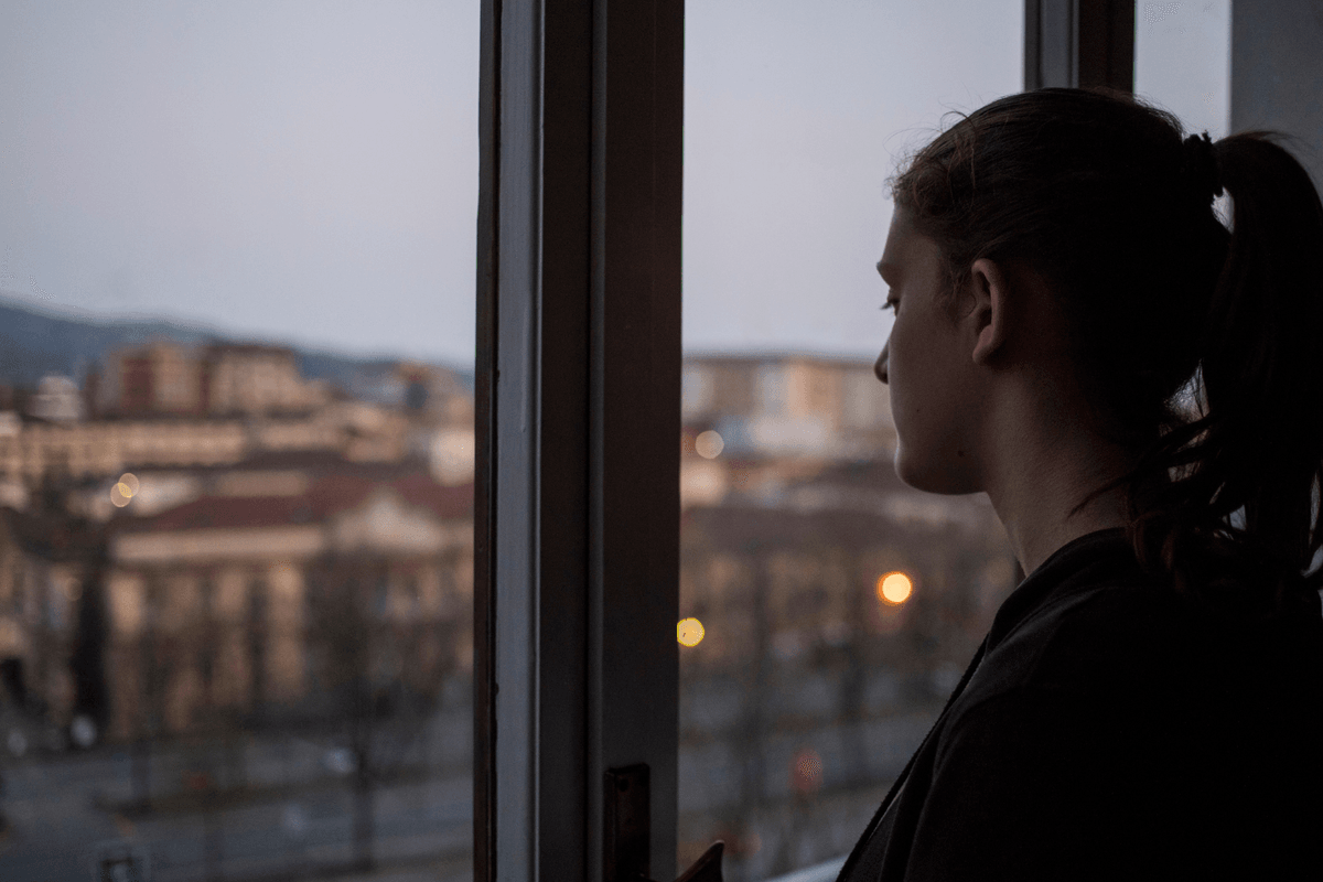Young woman looking out of window