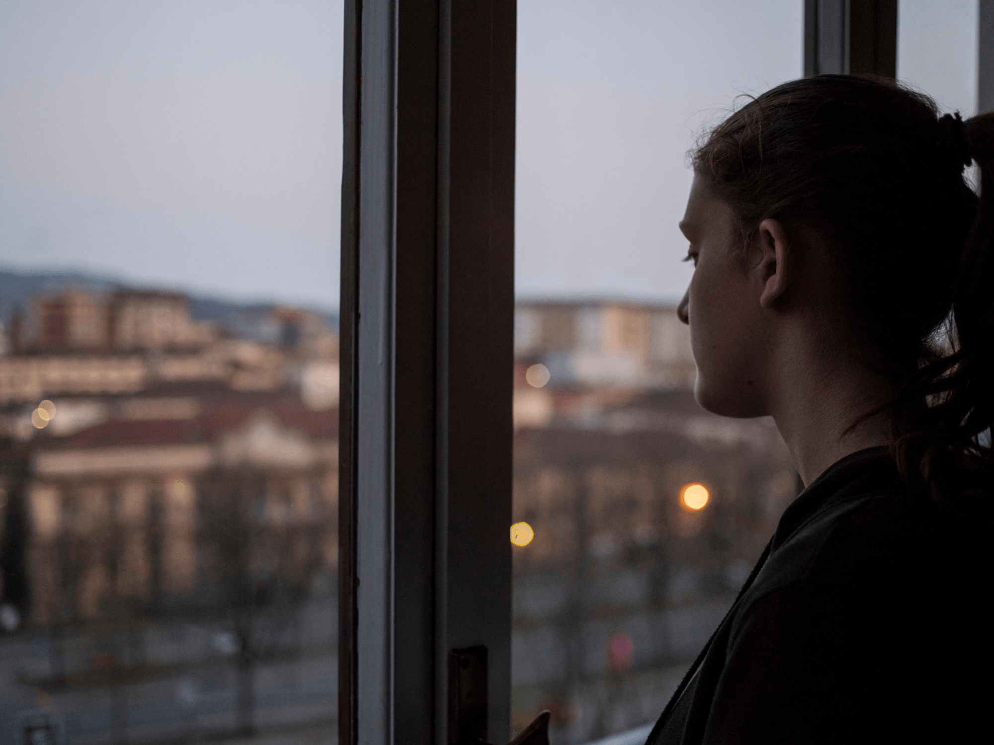 Young woman looking out of window