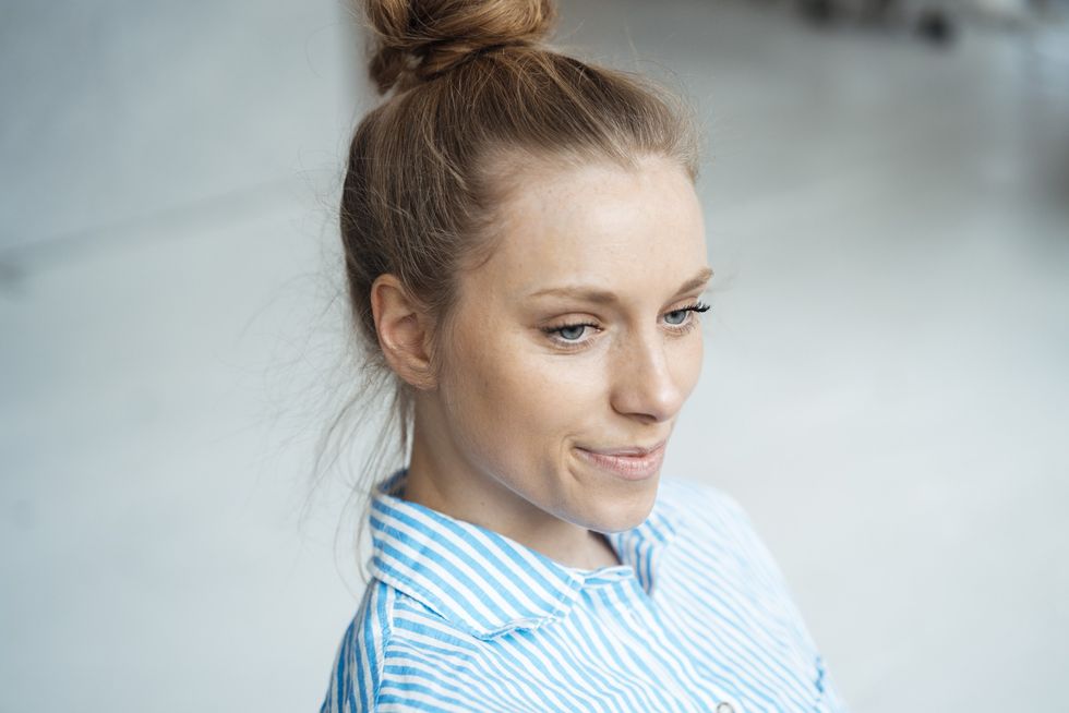 Young woman wearing her hair in a topknot