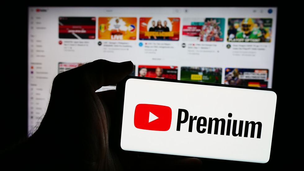 YouTube Premium  logo on smartphone with YouTube open on screen in background