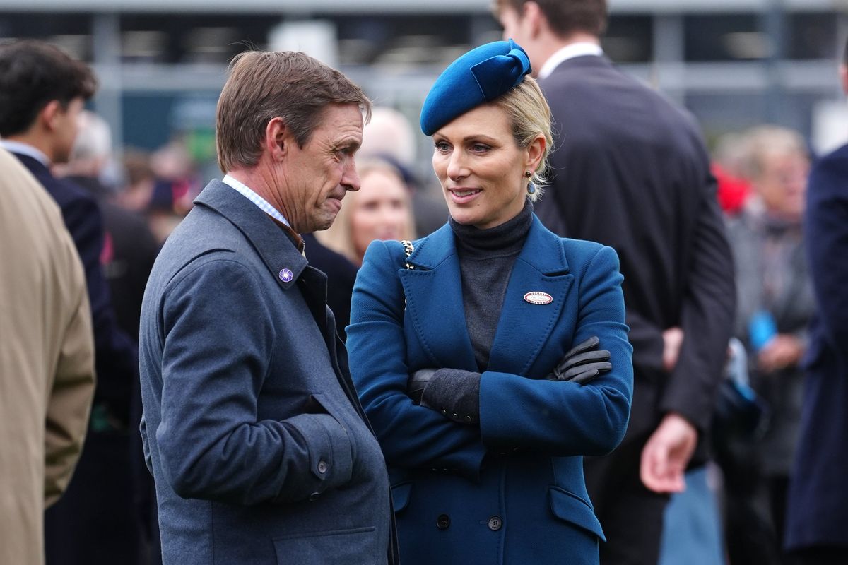 Zara Tindall battles the weather in blue at Cheltenham as she presents award to winning jockey