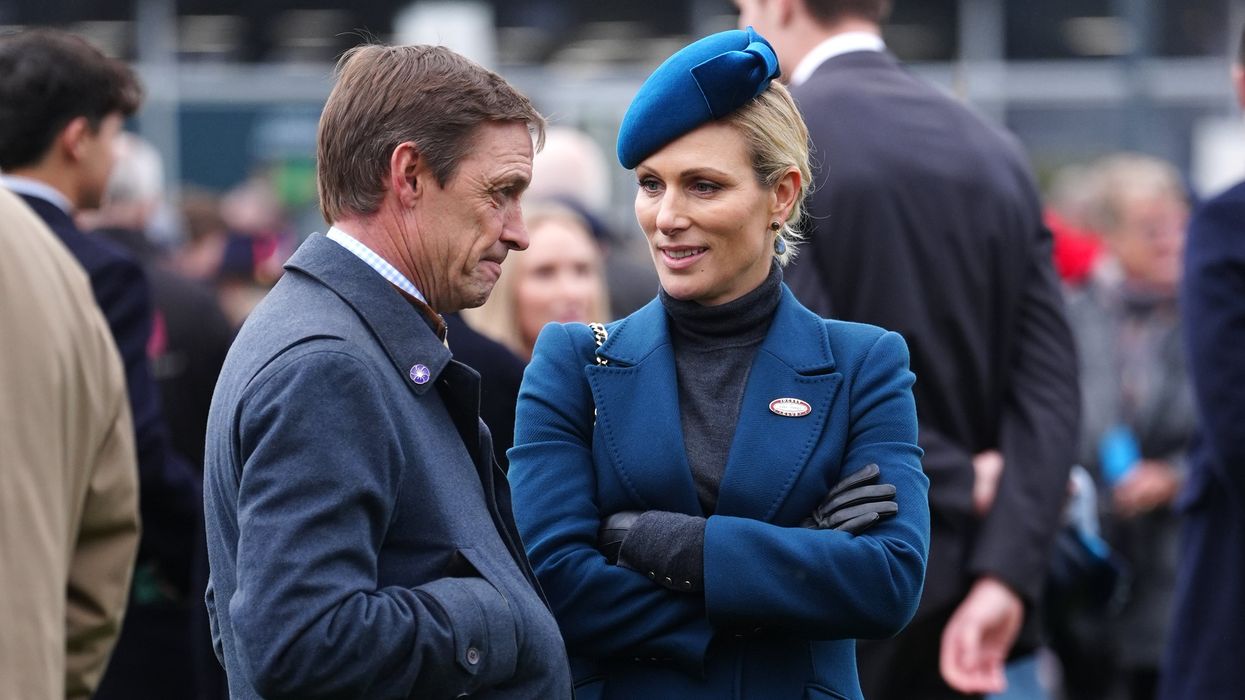 Zara Tindall battles the weather in blue at Cheltenham as she presents award to winning jockey