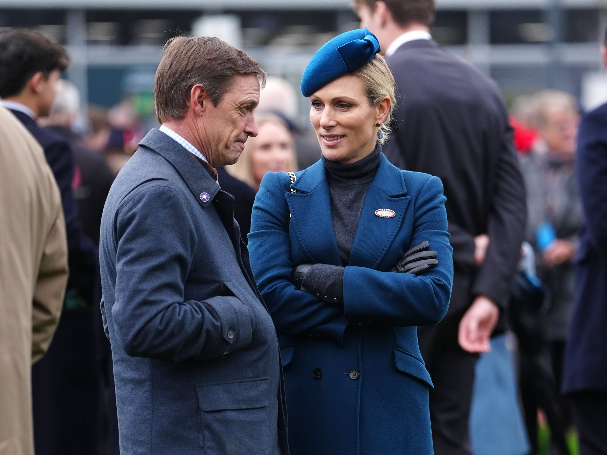 Zara Tindall braces the weather in blue at Cheltenham as she presents award to winning jockey