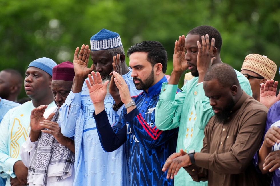 Zohran Mamdani stood with other Muslims while wearing the traditional loose-fitting tunic, which featured the Arsenal crest and Emirates sponsorship logo